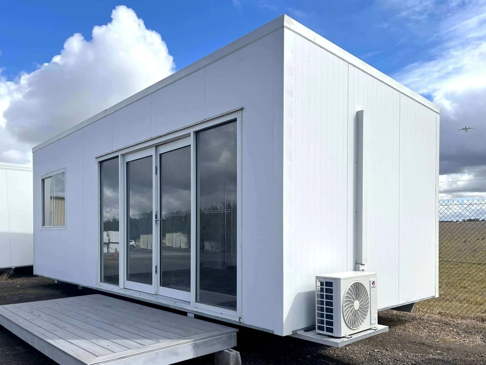 Modern white McGregor portable building with glass doors under open sky