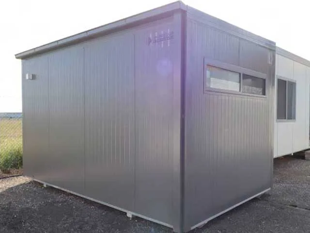 Grey site office exterior on a gravel yard