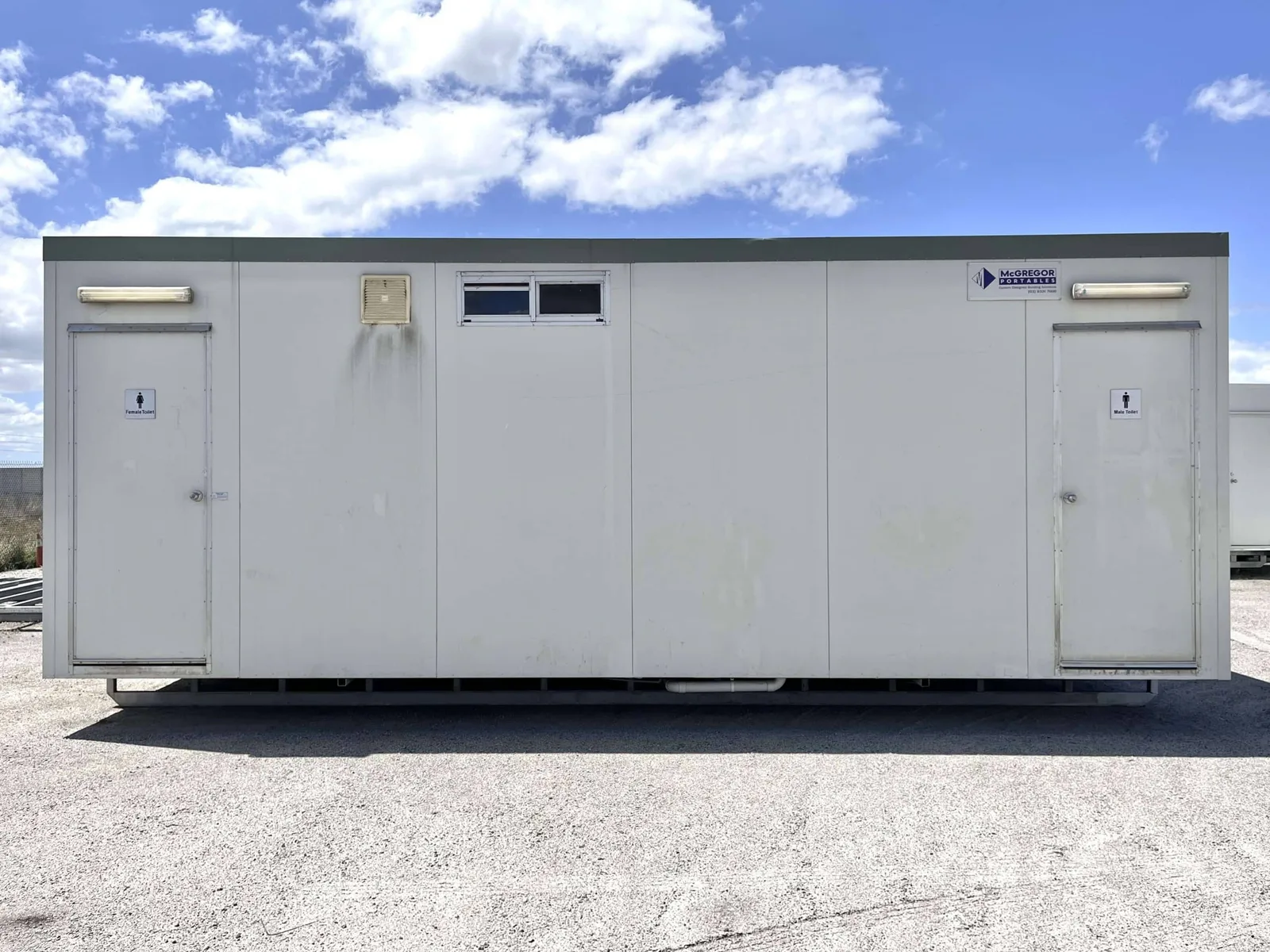 Long ablution block exterior with McGregor branding and blue sky
